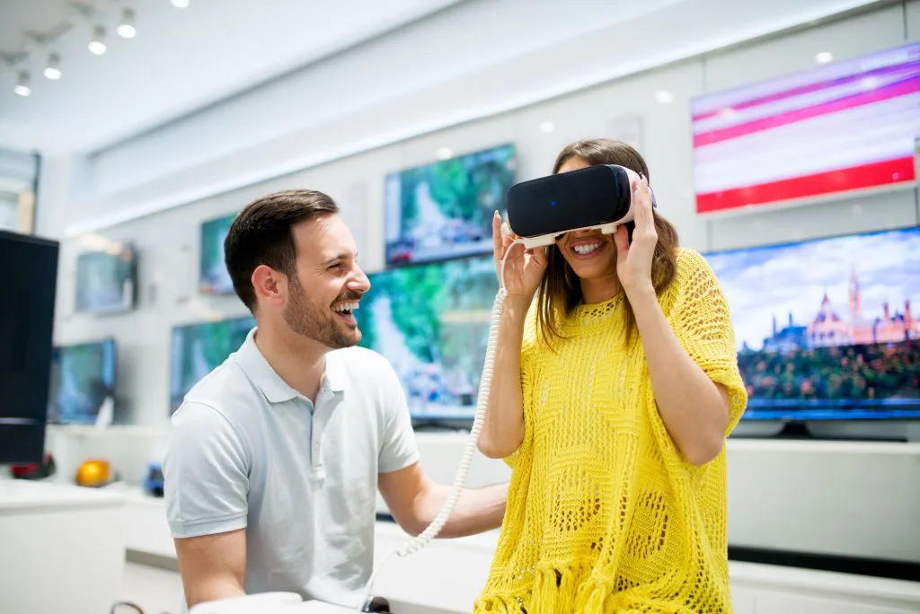 Tecnologia no varejo: mulher usando óculos de realidade virtual em loja de tecnologia