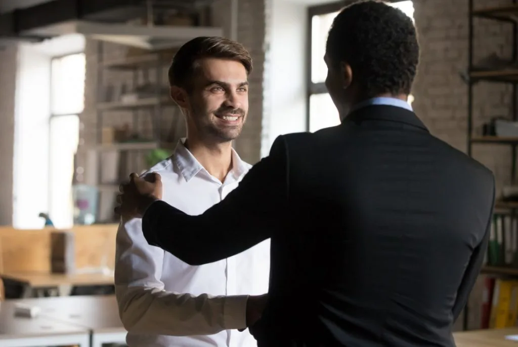cliente em destaque com sorriso no rosto porque está sendo bem atendido pelo vendedor que o atendeu. 