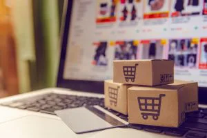 Compras on-line conceito - serviço de compras na web on-line. com pagamento por cartão de crédito e oferece entrega em domicílio. pacote ou caixas de papel com um logotipo de carrinho de compras em um teclado de laptop.