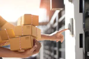Entregador segurando caixas de encomendas e tocar a campainha da porta do cliente no fundo da manhã.