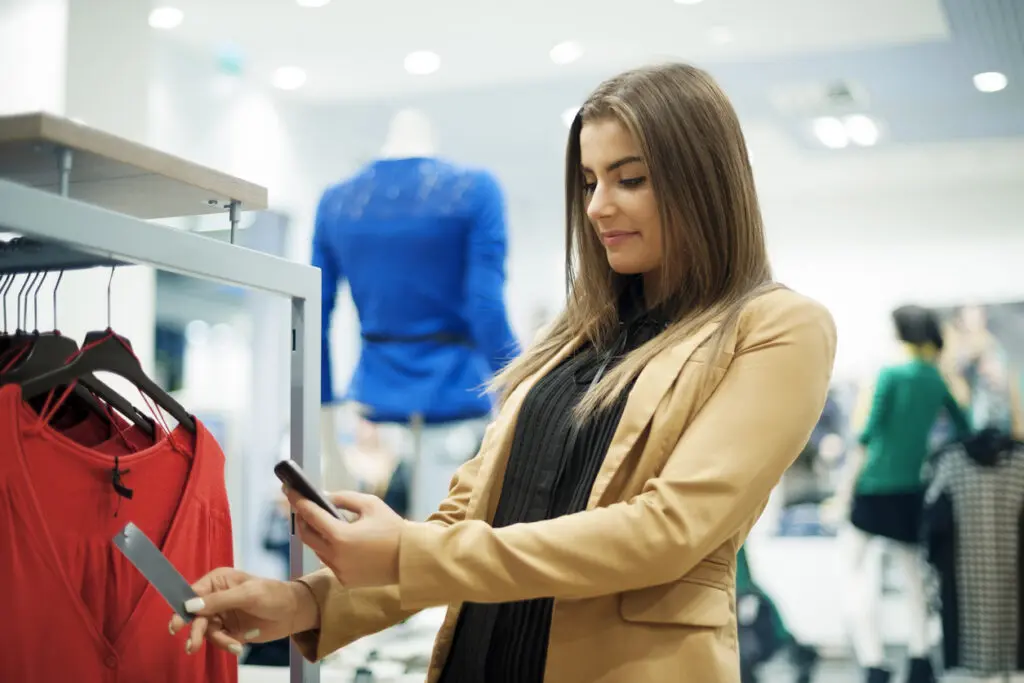 Mulher atraente verificando código de barras em shopping, realizando a avalição de cliente oculto.