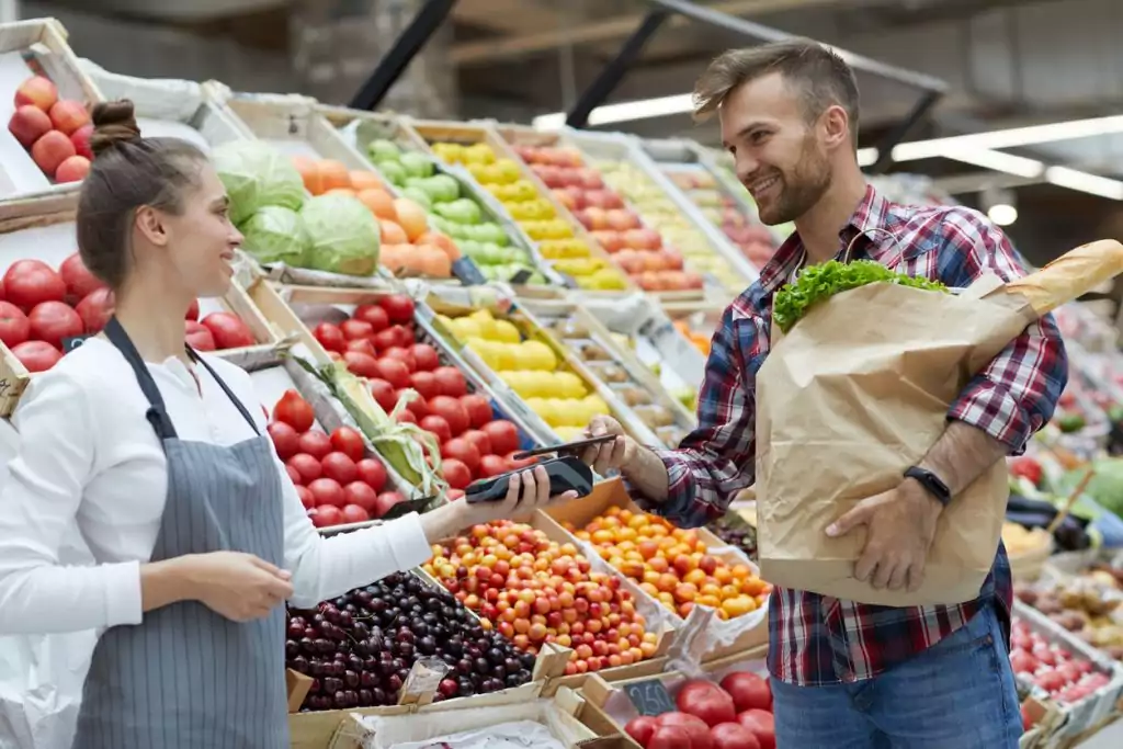 Cliente pagando por Smartphone no supermercado, uma tendência de PDV móvel.