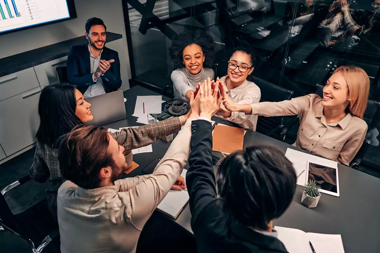 Empresários bem-sucedidos dão cinco uns aos outros. Grande equipe pronta para ir. O conceito de trabalho em equipe. Uma boa liderança influencia de forma direta no sucesso de um negócio.