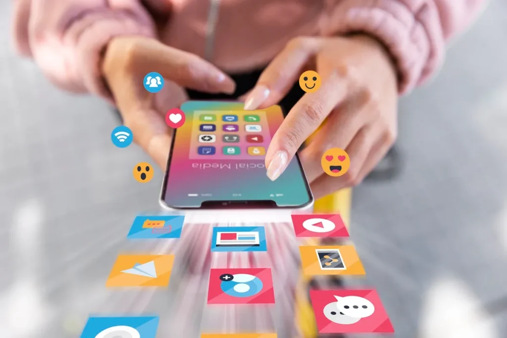 Mãos femininas interagindo com um smartphone, com ícones flutuantes representando redes sociais e aplicativos.