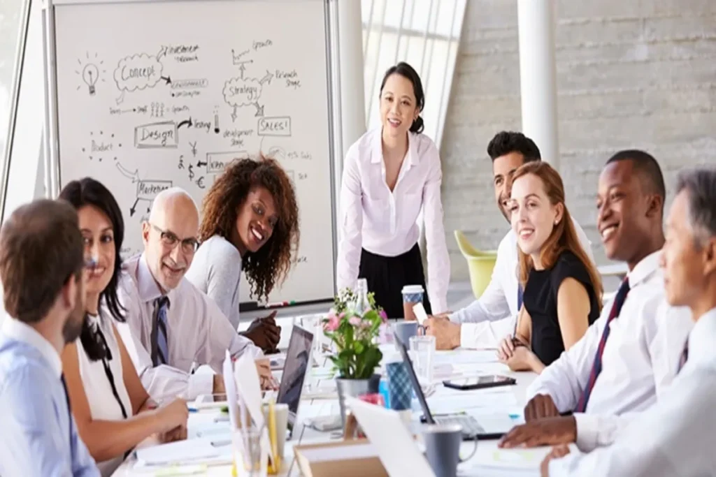 Um grupo de profissionais diversos em uma reunião de escritório, sorrindo e interagindo de forma positiva.