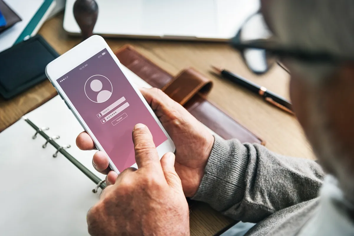 Pessoa fazendo login em um aplicativo de smartphone com campos para nome de usuário e senha
