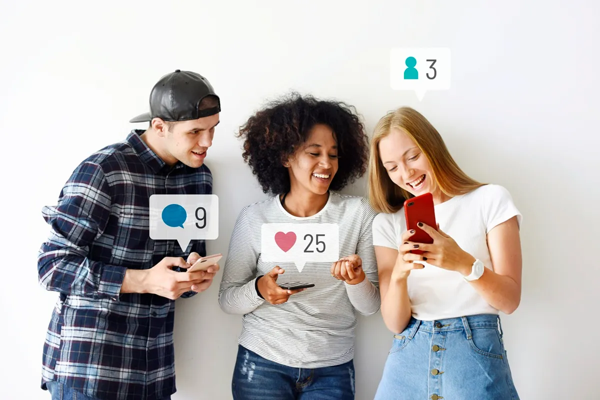 Três jovens consultam smartphones com balões de notificação: curtida ‘25’, comentário ‘9’ e novo seguidor ‘3