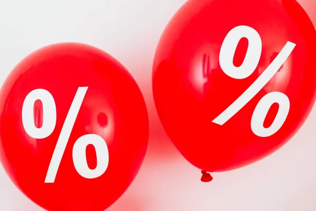 Balões vermelhos com símbolo de porcentagem em destaque representando promoção