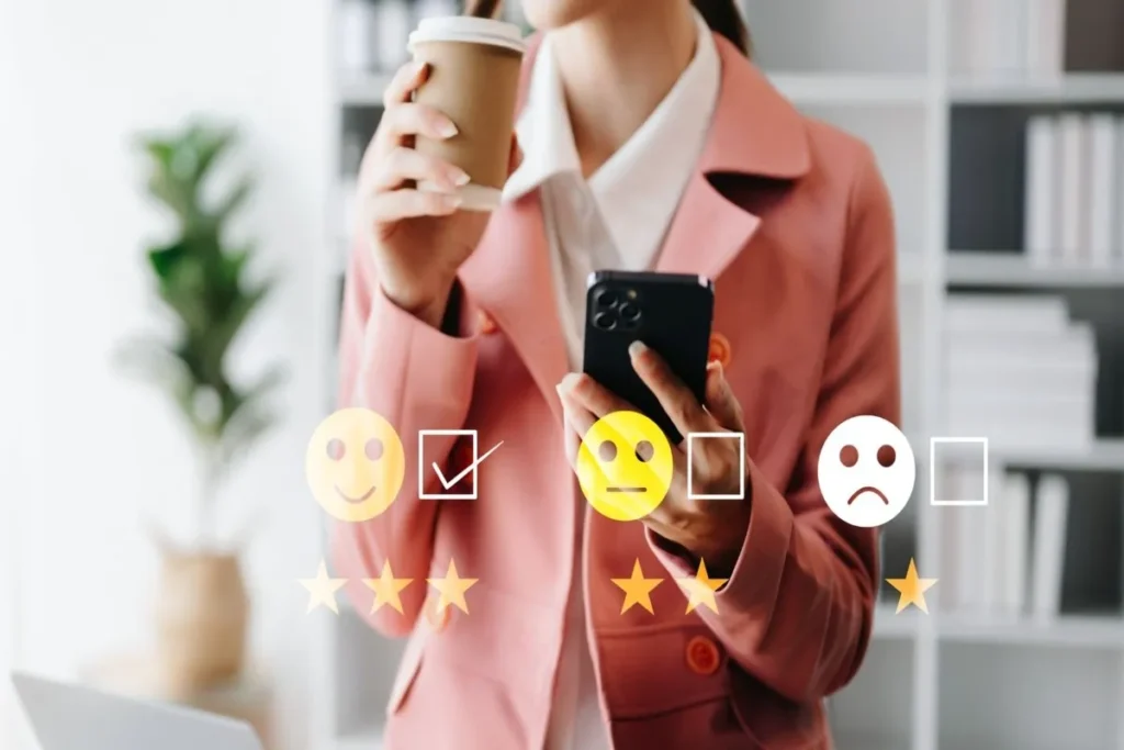 Mulher segurando celular e café, interagindo com avaliação de pesquisa online com emojis de satisfação.