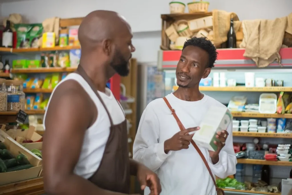 Cliente conversando com atendente em supermercado, ilustrando a dinâmica das vendas B2C e as relações B2B de fornecimento.