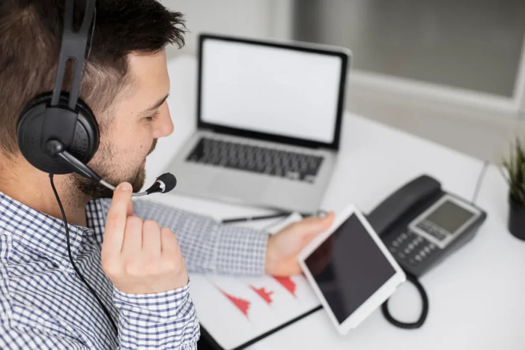 Homem usando um headset com microfone e segurando um tablet, representando coesão e comunicação em um ambiente de trabalho ou atendimento ao cliente.