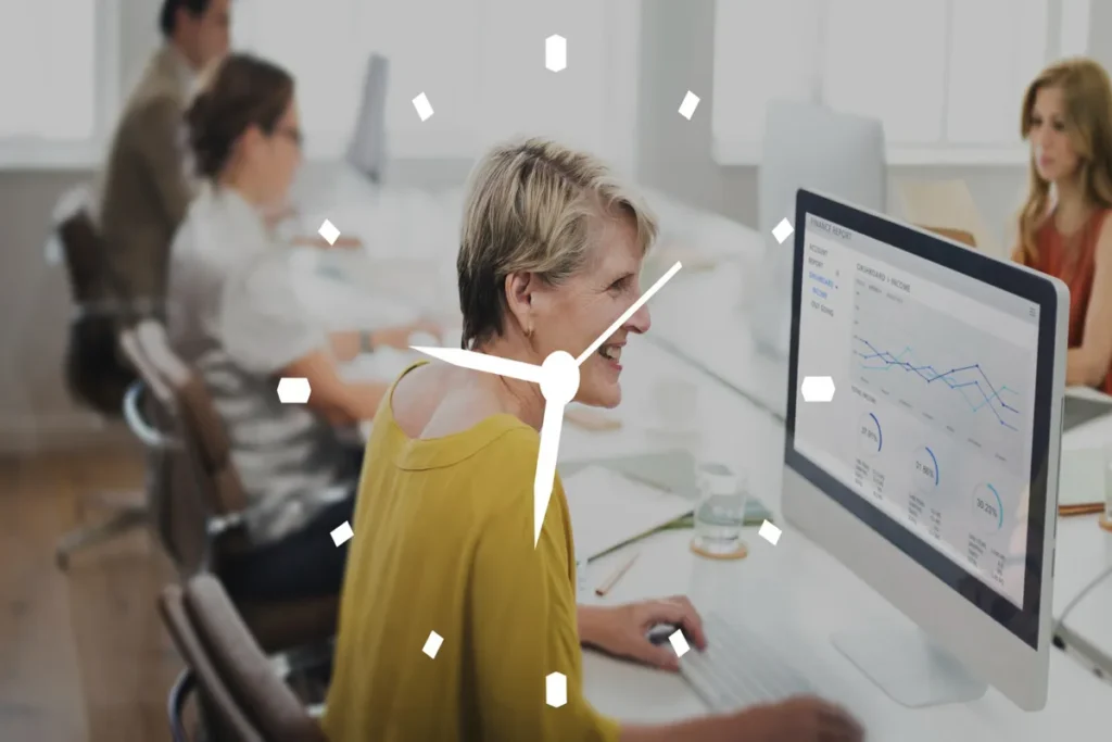 Mulher de negócios de meia-idade sorrindo e trabalhando no computador em um escritório, com um relógio digital sobreposto, simbolizando produtividade e gestão de tempo.